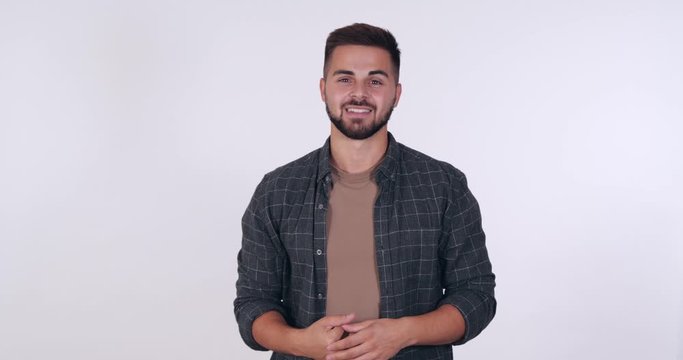 Handsome young man sarcastically applauding on white background