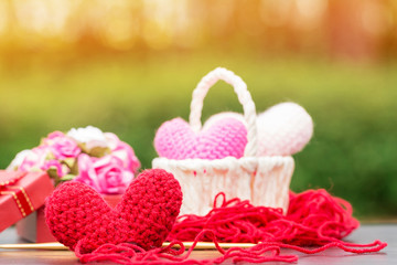 Knitting red heart-shaped with yarn as art crafts to give someone love put on the table in the public park, for give supporting when people get who lack of desire with love and Valentine day concept.