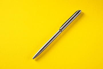 metal pen isolated on yellow background