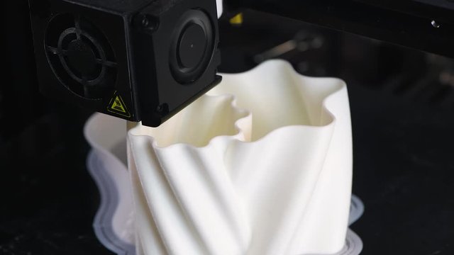 The 3D printer prints the model out of white plastic. Modern techology. 4K HD