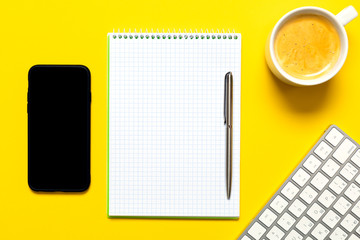 Top view of business working place with cup of coffee, Empty workspace on yellow table background.