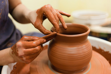 Fototapeta na wymiar Potter gives final shape to clay product