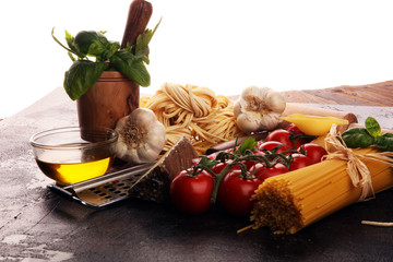 Fototapeta na wymiar Pasta, vegetables, herbs and spices for Italian food on rustic table