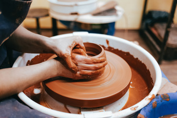 Potter forms a clay jug. Process of creating ceramic products. Woman works on a pottery wheel