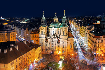 Fototapeta na wymiar Aerial view of Old Town square with illuminated St. Nicholas' Church, a hussite place of worship built in the 12 century at night in Prague, Czechia