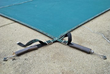 backyard swimming pool with diving board and pool slide tarped up and closed down for winter