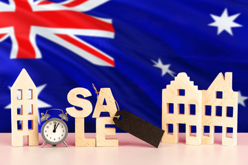 Australia real estate sale concept. Wooden house model with discount tag on national flag background. Copy space for text.