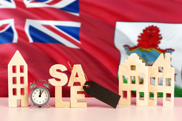Bermuda real estate sale concept. Wooden house model with discount tag on national flag background. Copy space for text.