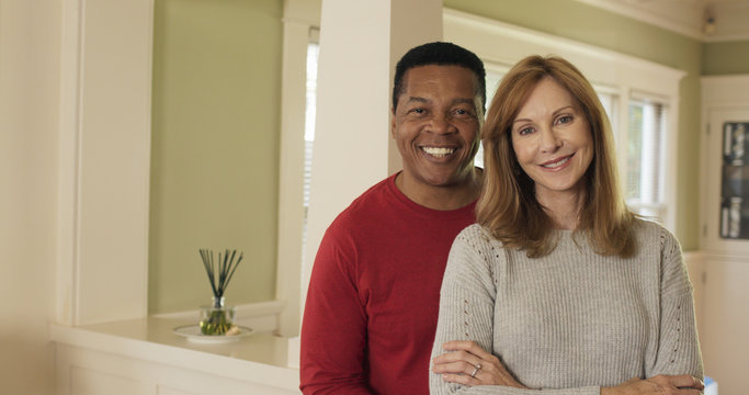 Dolly Shot of older couple standing in their home smiling