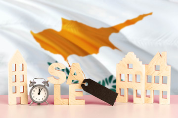 Cyprus real estate sale concept. Wooden house model with discount tag on national flag background. Copy space for text.
