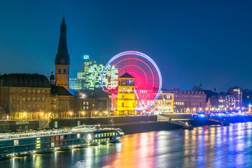 Fototapeta na wymiar Düsseldorf rhine river front and old town with Schlossturm museum and ferris wheel during night 