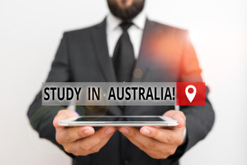 Handwriting text writing Study In Australia. Conceptual photo going into foreign country order complete your studies Male human wear formal work suit hold smart hi tech smartphone use hands