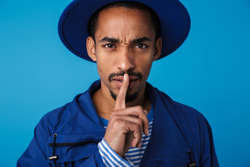 Photo of displeased african american man gesturing silence sign