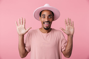 Photo of happy african american man wearing hat smiling with hands up