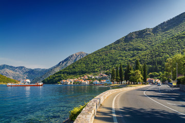Sunny morning view of Kotor bay and coastal road near Tivat, Montenegro.