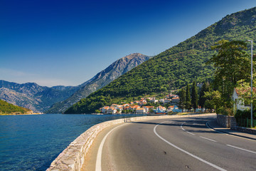 Sunny morning view of Kotor bay and coastal road near Tivat, Montenegro.