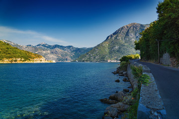 Sunny morning view of Kotor bay and coastal road near Tivat, Montenegro.