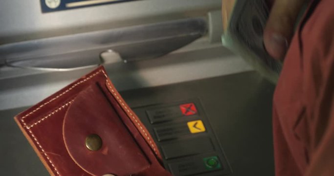 Man taking money out of cash machine outdoors, closeup