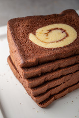 Chocolate bread stuffed with jam rolls topped with chocolate sauce