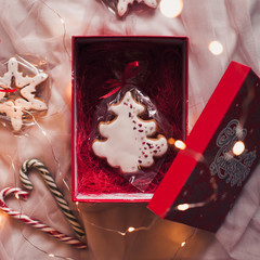 Red box with hand made ginger bread and candy cane closeup. Top view. Winter holiday season. Xmas time.