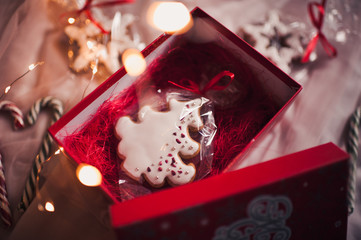 Christmas gingerbread in xmas tree shape over glowing lights closeup. Winter holiday season.