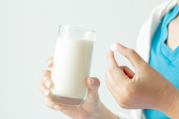 Women are taking medicine and holding a glass of milk. health care concept.