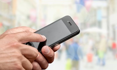 Hand holding smartphone on blurred bokeh background