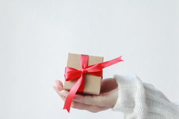 hand holding red gift box with bow isolated on white background