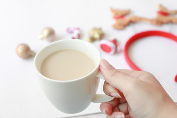 Obraz na płótnie Canvas Hand take out cup of coffee. Christmas decoration on table.