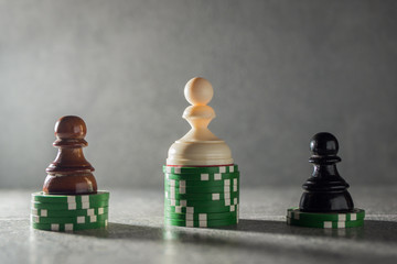 Wealth and income inequality concept. Pawns standing on stacks of green casino chips.