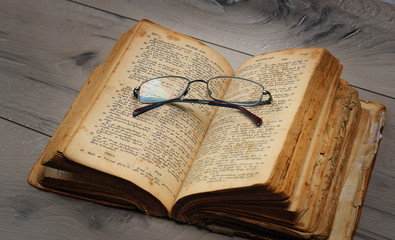 Open book with optical glasses. Old medieval Bible in Armenian language. selective focus, shallow...