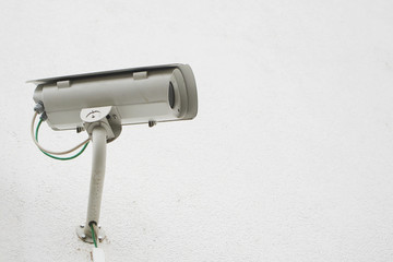 surveillance camera against a white wall with copy space