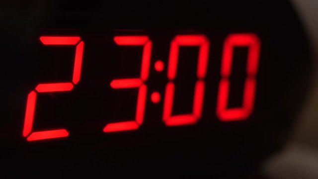 Close-up of black digital clock screen showing 23.00. Modern timer system 