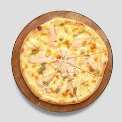 Appetizing pizza on a wooden board isolated on a gray background. Top view.