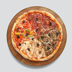 Appetizing pizza on a wooden board isolated on a gray background. Top view.