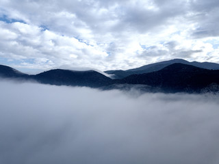 Fototapeta na wymiar Aerial view of a mountain in the fog, Tuscany, Italy.