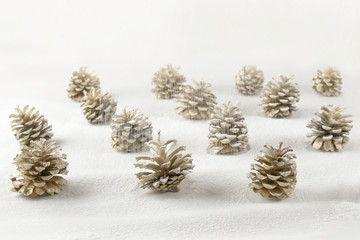 Fototapeta na wymiar Christmas decoration cones covered snow made of icing sugar. Christmas forest concept background. Golden colored pine cones covered sugar powder..