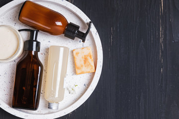 Organic natural herbal cosmetics on black wooden background.