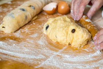Female hands prepare yeast dough with raisins for pies