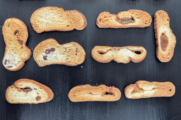 Wheat rusks on a wooden dark background.