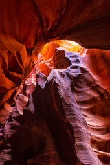 Wide angle vertical view of shadows and light at upper Antelope slot canyon with wave shape abstract formations of red orange rock layers sandstone in Page