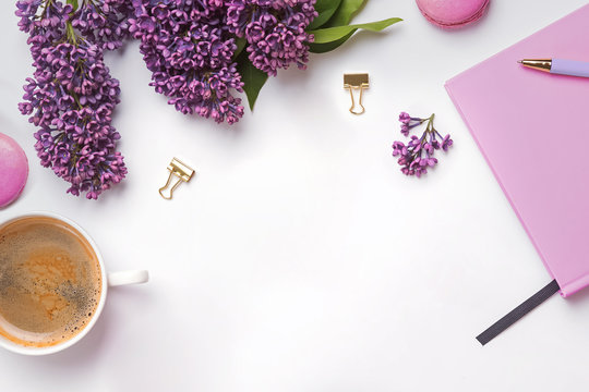 Creative composition with feminine accessories, beautiful lilac flowers, coffee and macarons