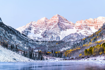 Maroon Bells morning sunrise with sunlight on peak in Aspen, Colorado rocky mountain and autumn yellow foliage view closeup and winter snow frozen lake - Powered by Adobe