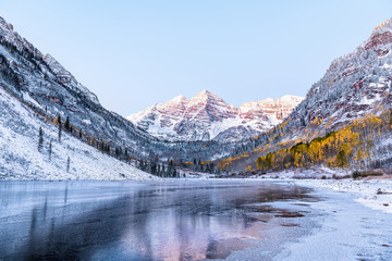 Maroon Bells morning sunrise reflection with sunlight on peak in Aspen, Colorado rocky mountain and...