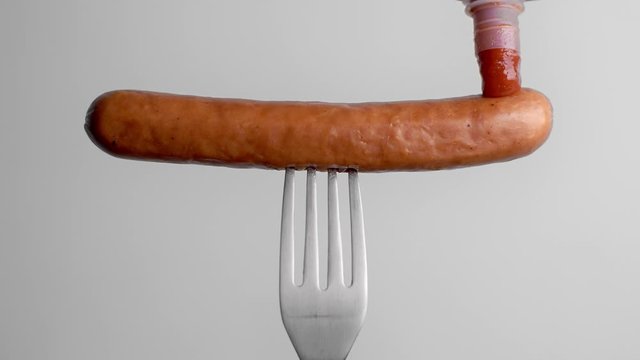 Tomato hot sauce drops to the sausage in slow motion, tomato ketchup with meat, sausage on fork, Full HD 120fps Prores HQ