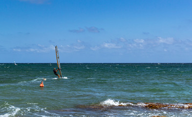 surfista in mare vicino agli scogli