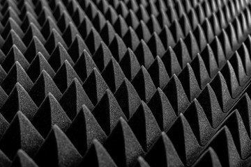 Abstract background in the form of pyramids and dragon scales. Acoustic black foam rubber.