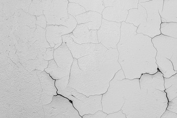 Cracked flaking white paint on the wall, background texture