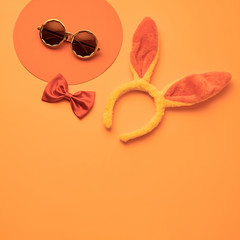 Fashion party girl layout Flat lay. Minimal. Woman Essentials night club accessories. Trendy sunglasses, rabbit. Coloful vibrant orange Set. Creative pop art fashionable concept