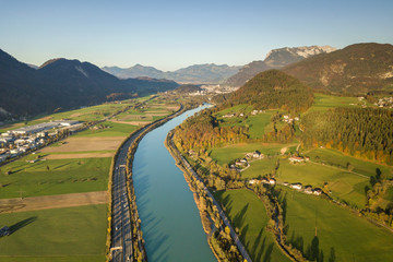 Aerial view of highway interstate road with fast moving traffic near big river in Alps mountains